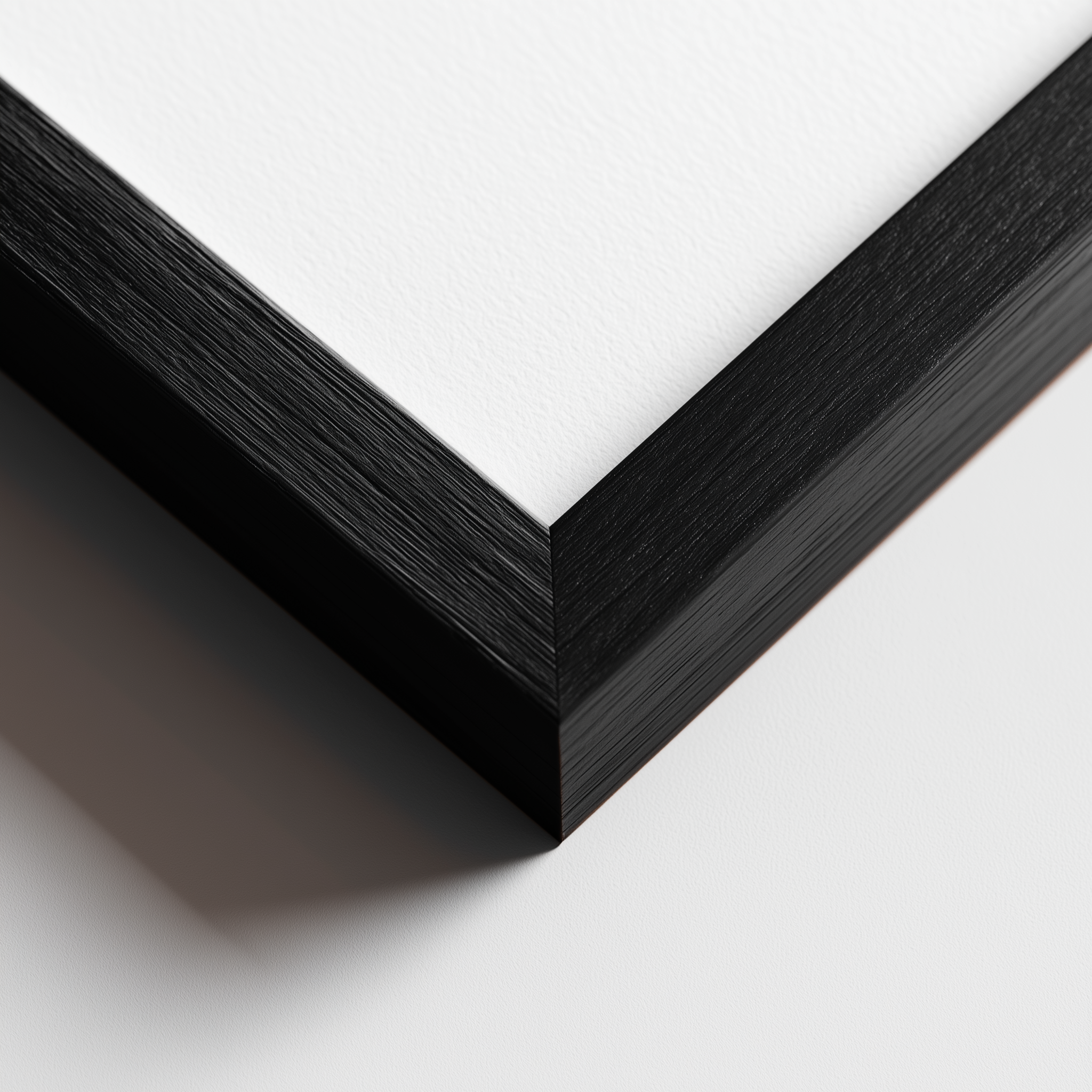 Close-up of a black wooden picture frame corner on a white background